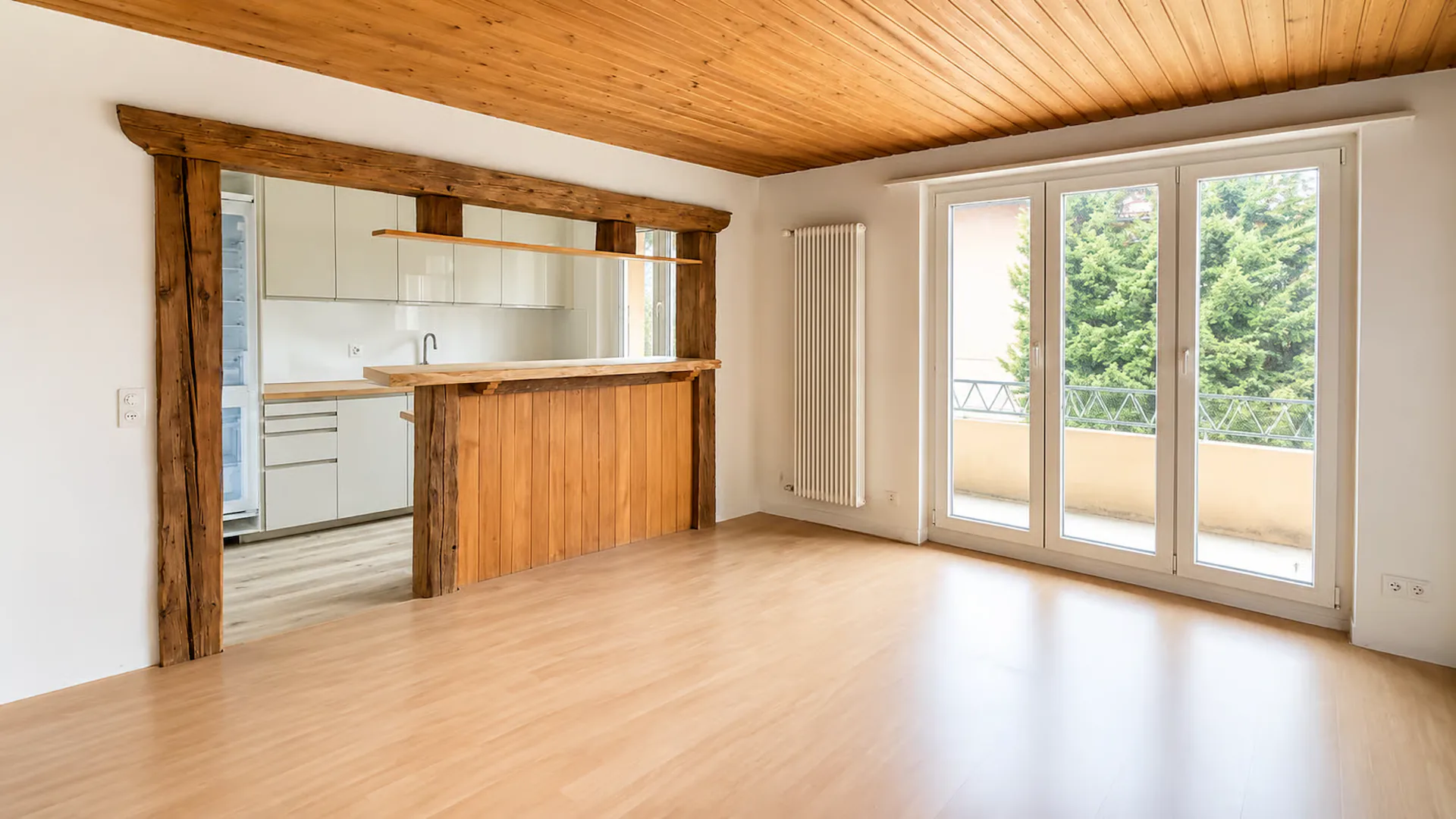 Bright living and dining area, modern open kitchen, and inviting balcony