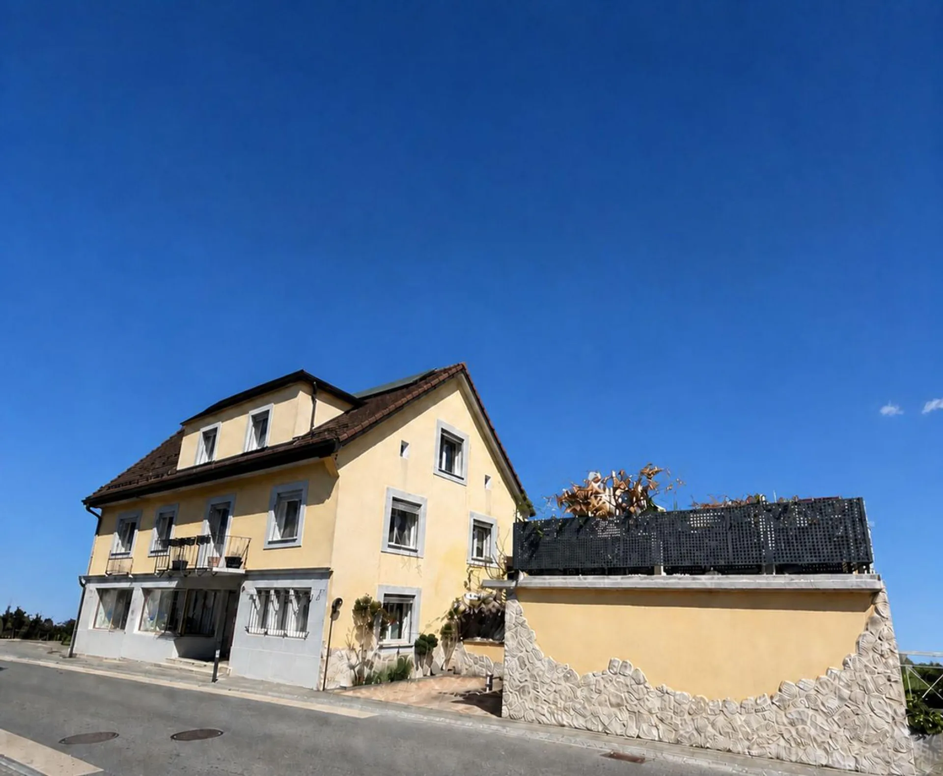 Immeuble de 2 appartements, un local commercial - 2 chambres- 2 places de parc et un garage/ Terrasse au centre du village